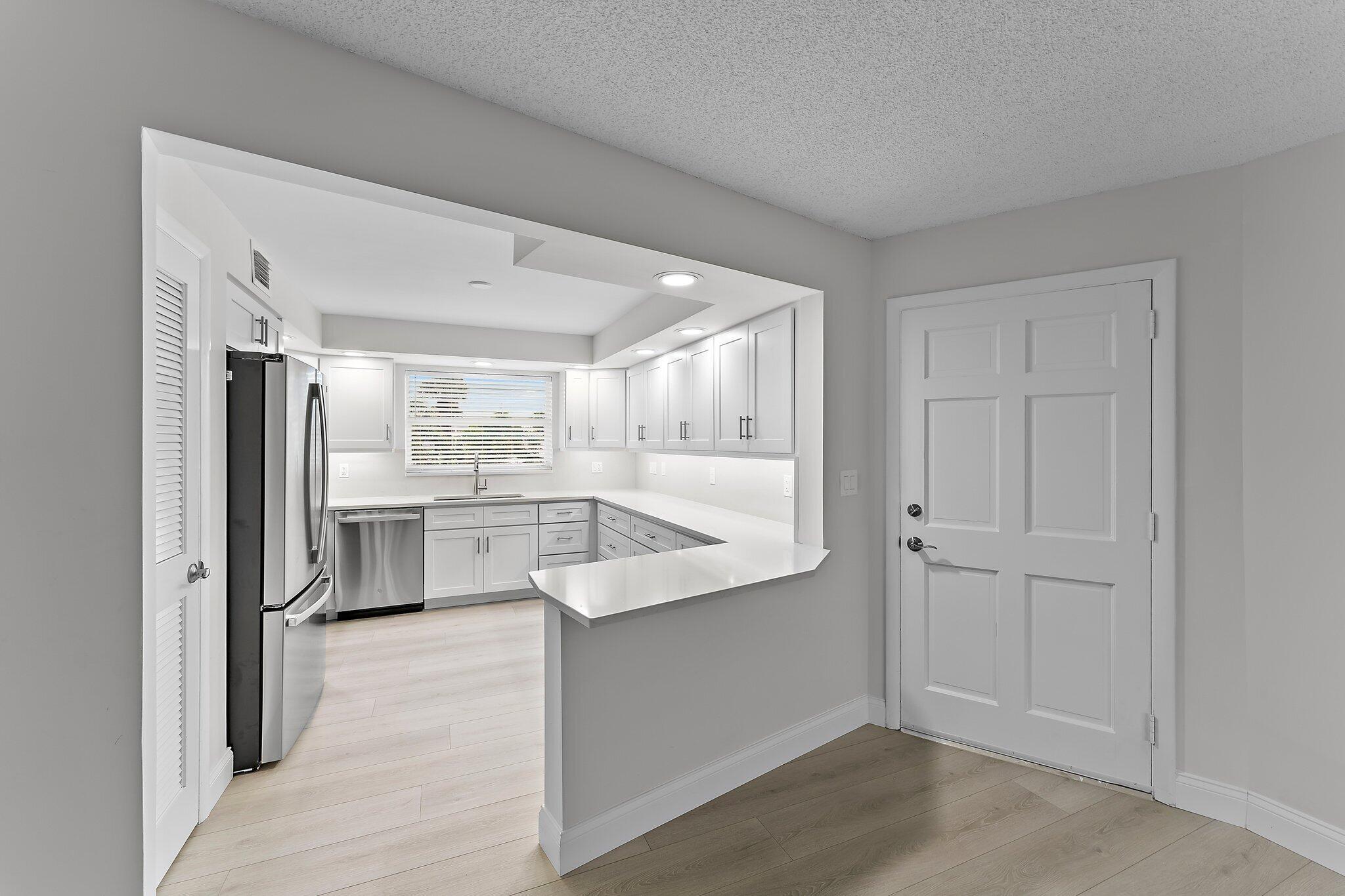 20 Celestial Way, Unit 215 Juno Beach, FL 33408 - Photo 4 of 25 a view of a kitchen with white cabinets