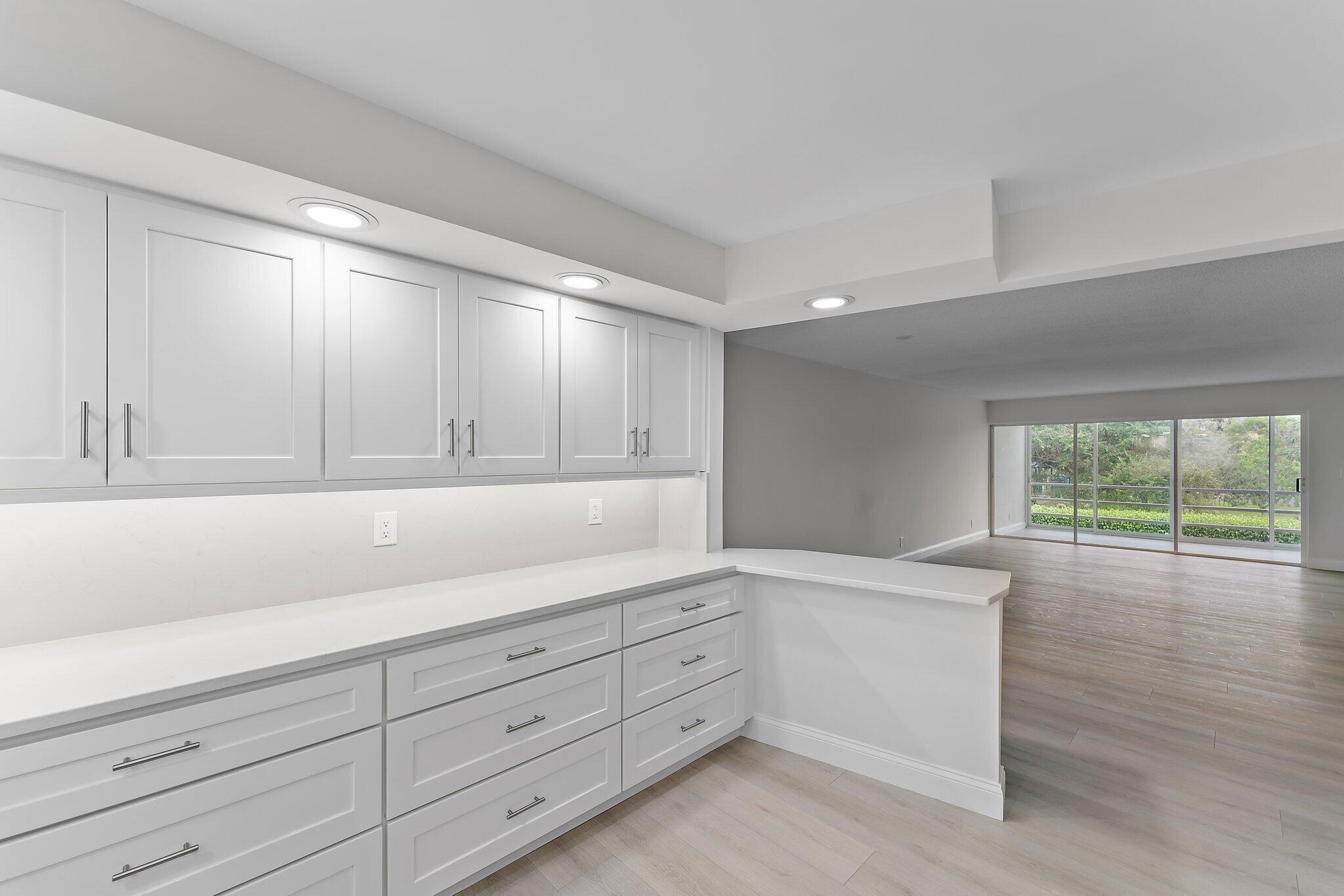 20 Celestial Way, Unit 215 Juno Beach, FL 33408 - Photo 7 of 25 a kitchen with granite countertop white cabinets and window