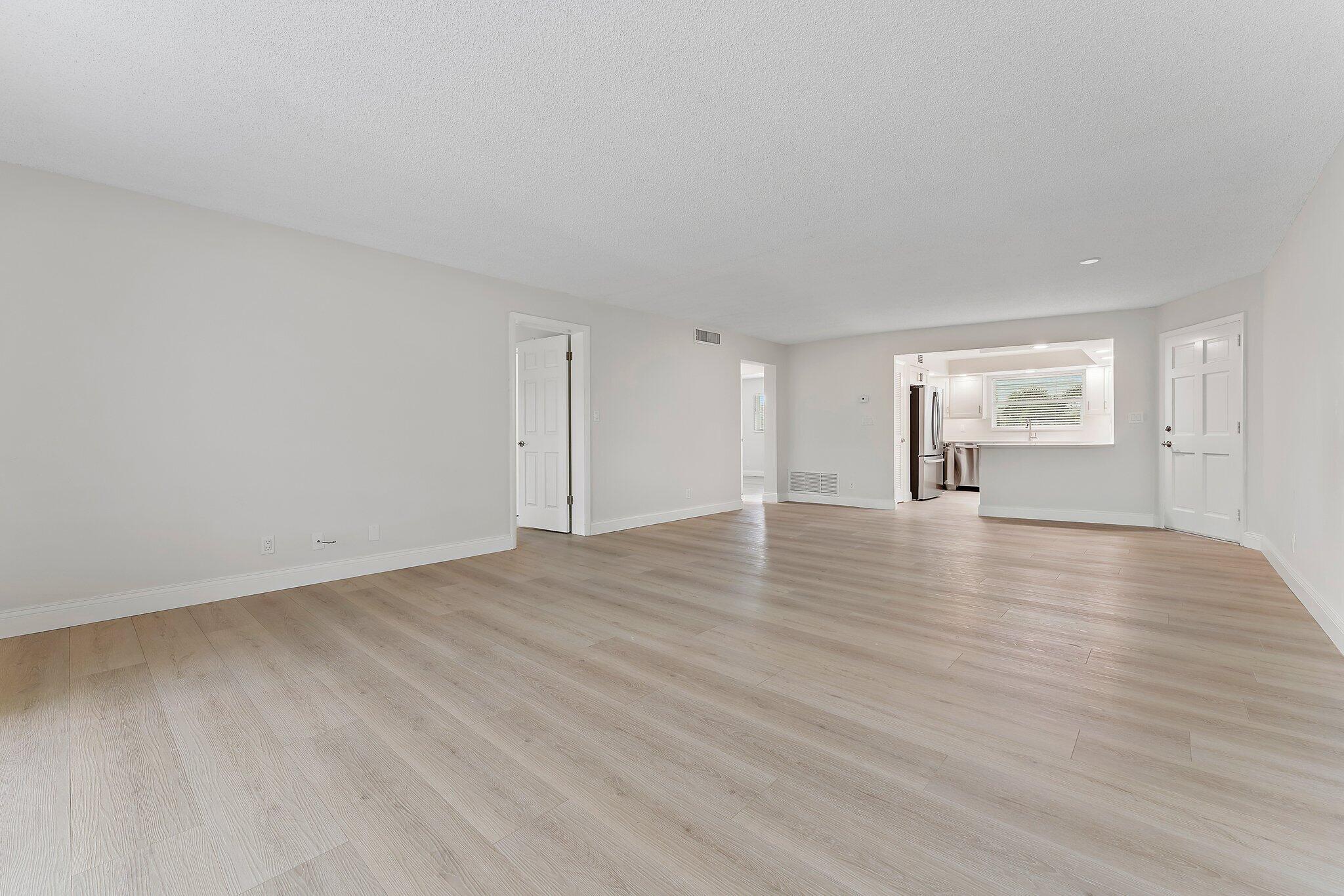 20 Celestial Way, Unit 215 Juno Beach, FL 33408 - Photo 10 of 25 a view of empty room with wooden floor and kitchen