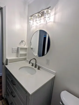 a bathroom with a toilet sink and mirror