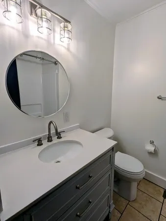 a bathroom with a sink a toilet and mirror