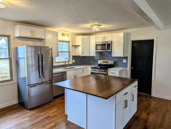 a kitchen with kitchen island a refrigerator stove and sink