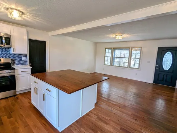 a kitchen with kitchen island wooden floors and stainless steel appliances