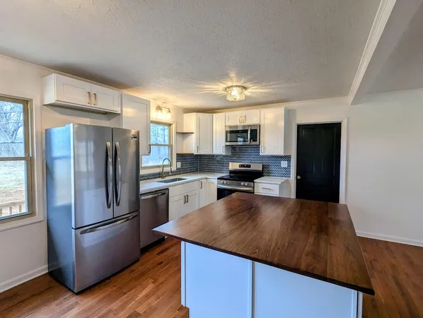 a kitchen with a refrigerator and a stove top oven