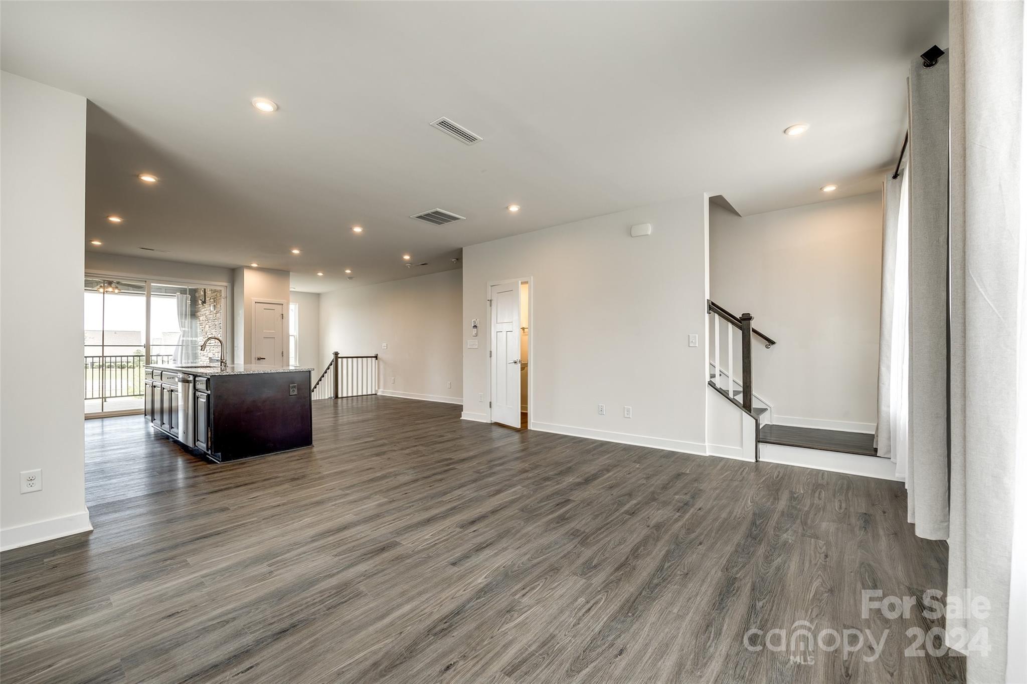 664 Crudent Road Tega Cay, SC 29708 - Photo 14 of 34 a view of an empty room with wooden floor and windows