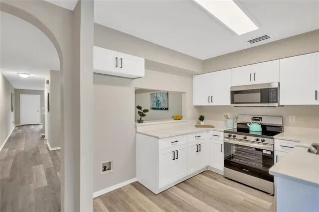 a kitchen with cabinets stainless steel appliances and sink