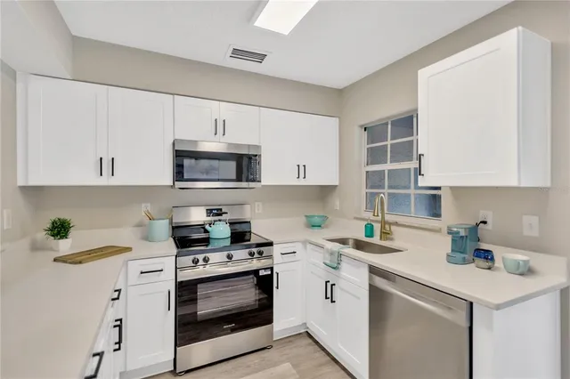a kitchen with cabinets stainless steel appliances and a counter space