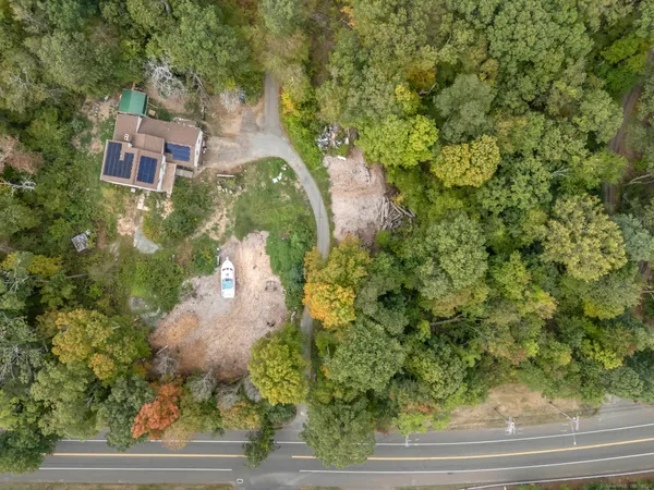 an aerial view of residential houses with outdoor space and trees