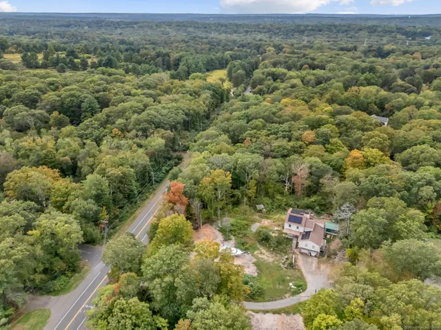 an aerial view of residential houses with outdoor space and trees