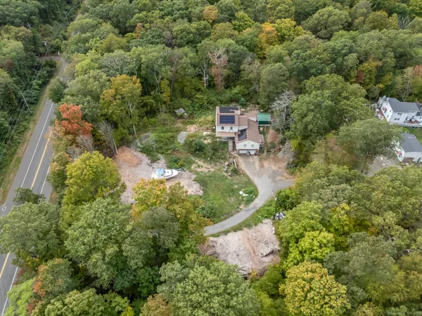 a aerial view of a house with a yard and large tree