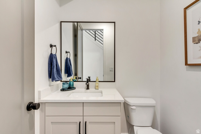 1389 1440 East, Unit 1 Payson, UT 84651 - Photo 8 of 17 Bathroom vanity featuring a white countertop with an integrated sink, matte black faucet, and a rectangular framed mirror