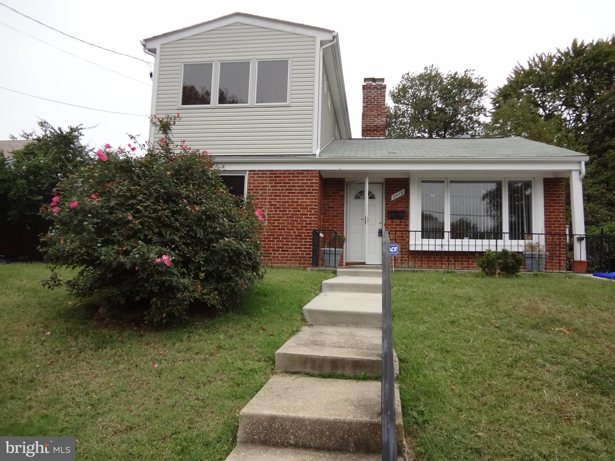 a front view of a house with a yard and trees