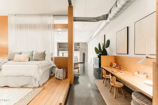 a bedroom with a bed and wooden floor