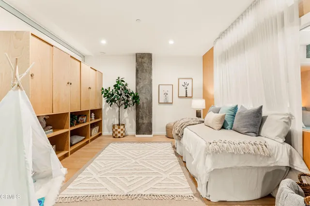 a bedroom with a bed and a large mirror with a bedroom