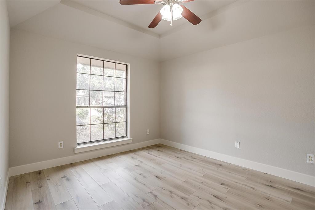 10311 Lone Pine Lane Fort Worth, TX 76108 - Photo 5 of 13 an empty room with wooden floor chandelier fan and windows