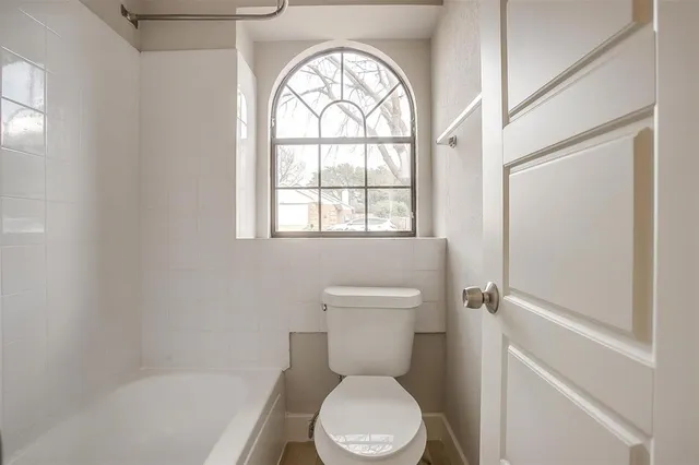 a white toilet sitting next to a window
