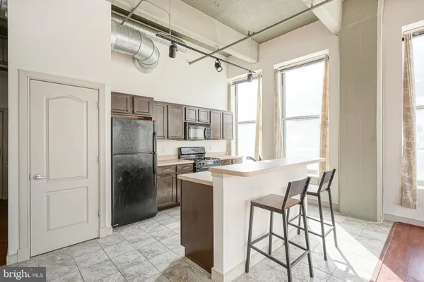 a kitchen with stainless steel appliances a table and chairs