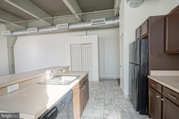 a kitchen with stainless steel appliances granite countertop a sink refrigerator and cabinets