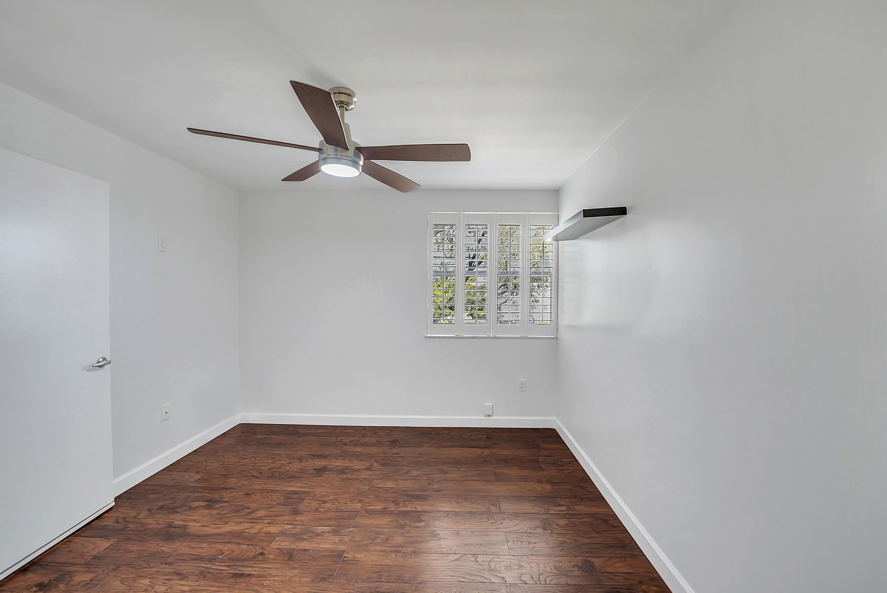 4550 Southwest 68th Ct Circle, Unit 548 Miami, FL 33155 - Photo 18 of 51 an empty room with wooden floor ceiling fan and windows