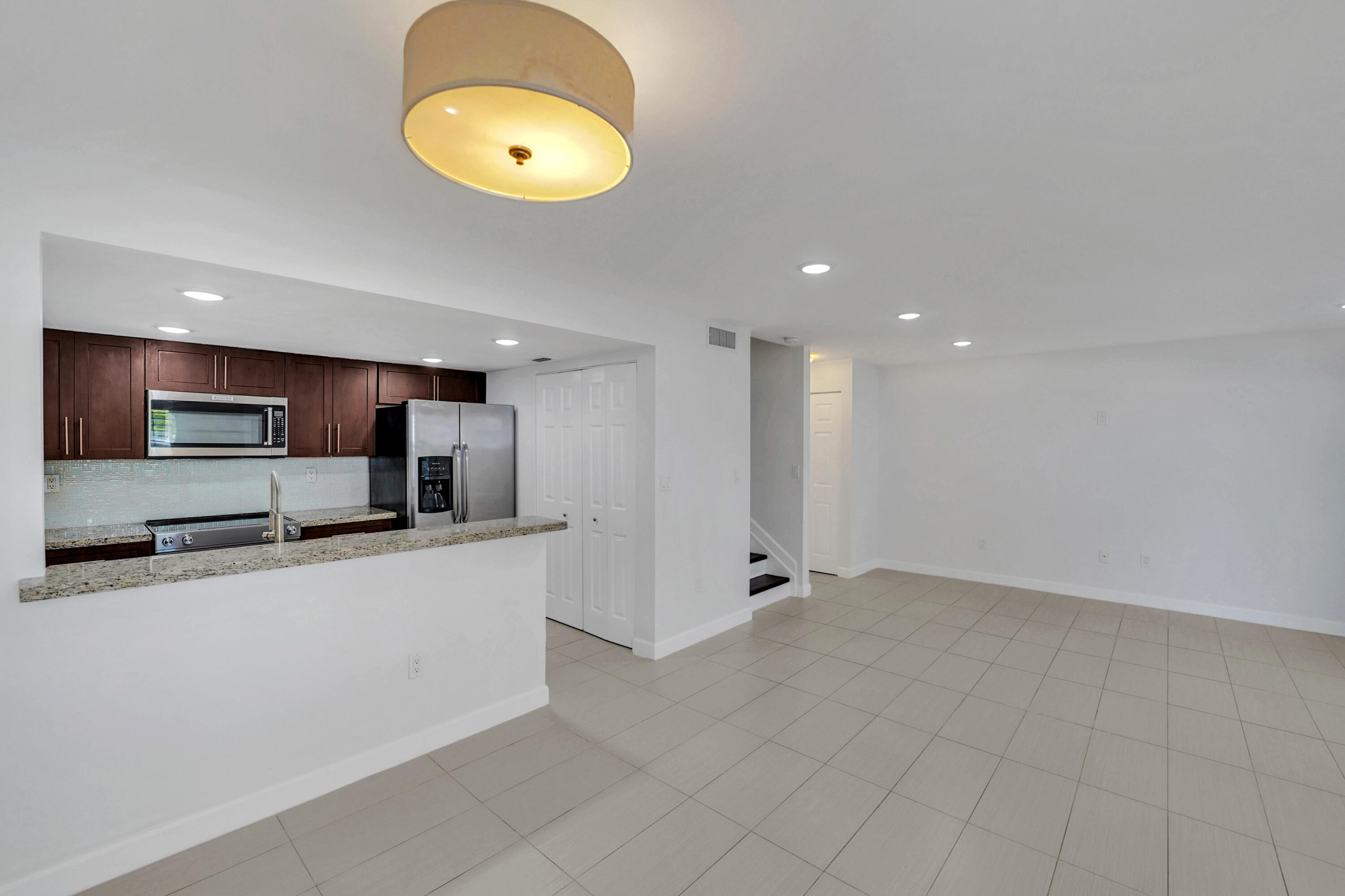 4550 Southwest 68th Ct Circle, Unit 548 Miami, FL 33155 - Photo 25 of 51 a large kitchen with stainless steel appliances lots of counter space and a refrigerator