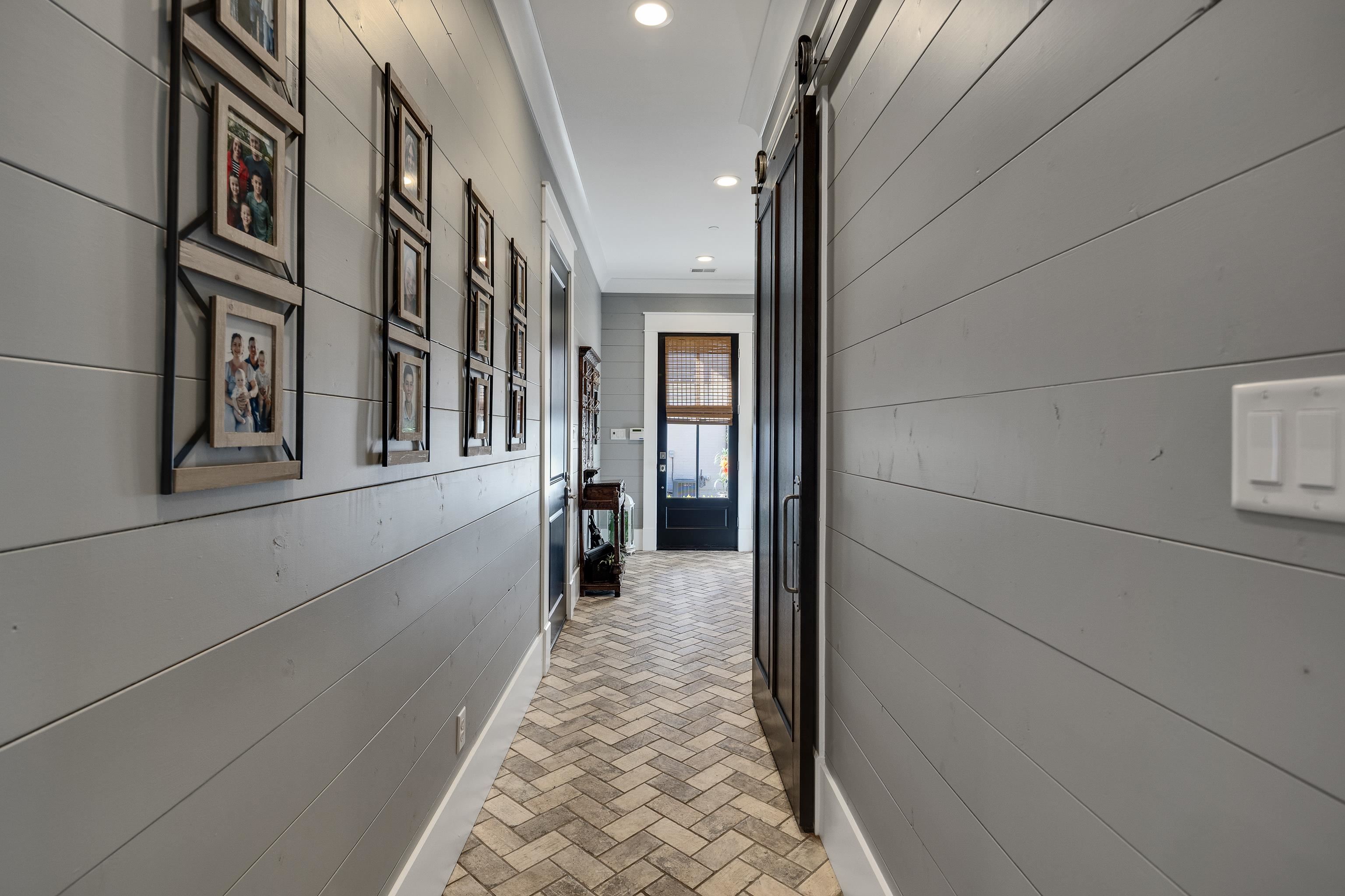 170 Twin Lakes Road Piperton, TN 38017 - Photo 23 of 40 Corridor featuring brick patterned floors, a barn door, wooden walls, and recessed lighting
