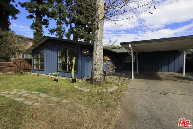 a view of a house with a porch and a tree