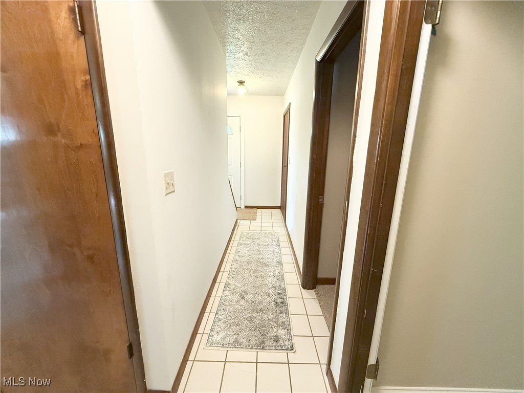 4901 Kings Creek Road Weirton, WV 26062 - Photo 16 of 28 Corridor with a textured ceiling and light tile patterned floors