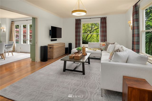 a living room with furniture a flat screen tv and a large window