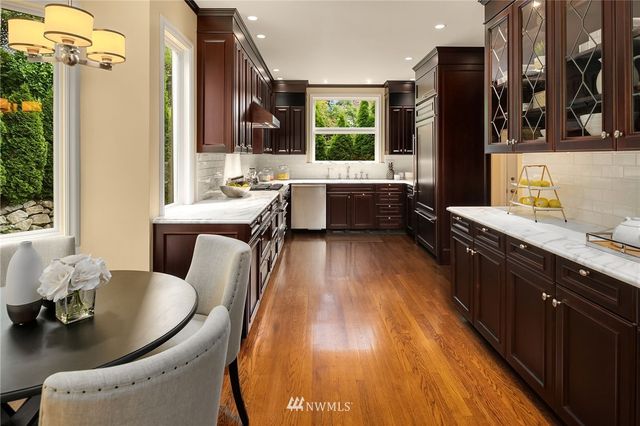 a large kitchen with stainless steel appliances kitchen island granite countertop a sink a counter space and a window