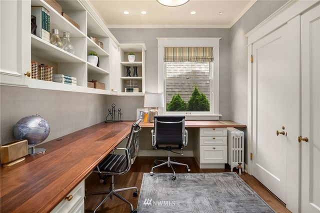 a view of a workspace with furniture and a window