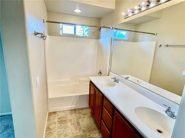a bathroom with a sink and mirror with bathtub
