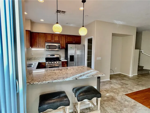 a kitchen with kitchen island a counter space a sink appliances and cabinets
