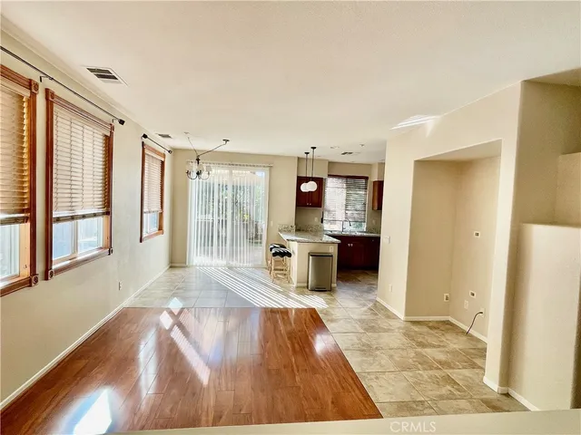 a living room with stainless steel appliances kitchen island granite countertop furniture and a wooden floor