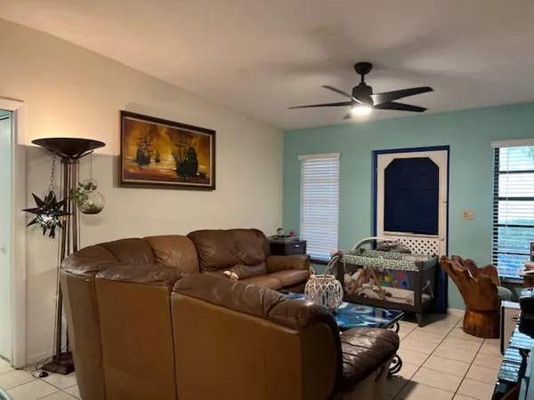 a living room with furniture and a ceiling fan