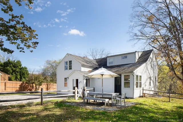 a view of a house with a big yard potted plants and large tree