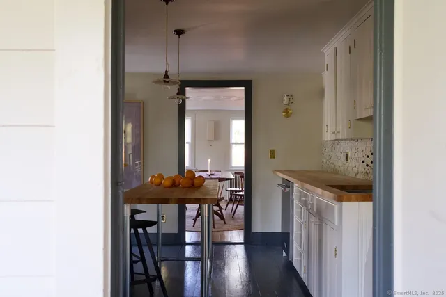 a view of a kitchen area with furniture and wooden floor