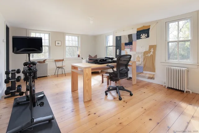 a view of a livingroom with workspace and a window