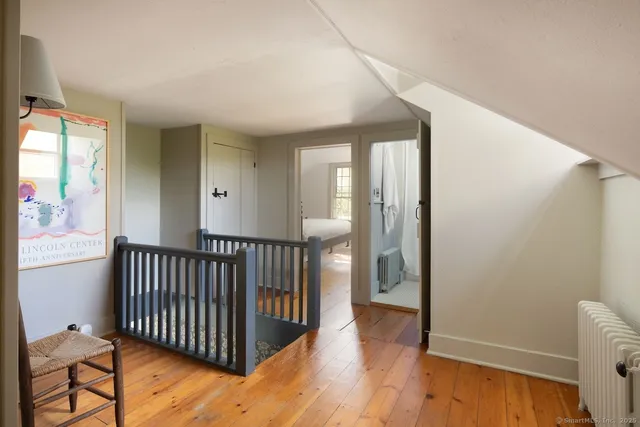 a view of a hallway with wooden floor and windows