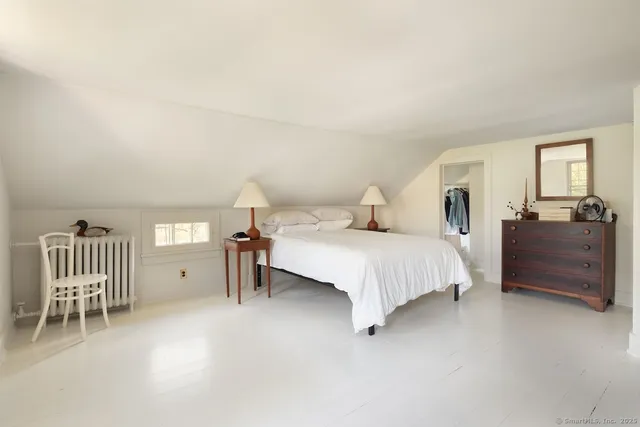 a bedroom with a bed and a chair