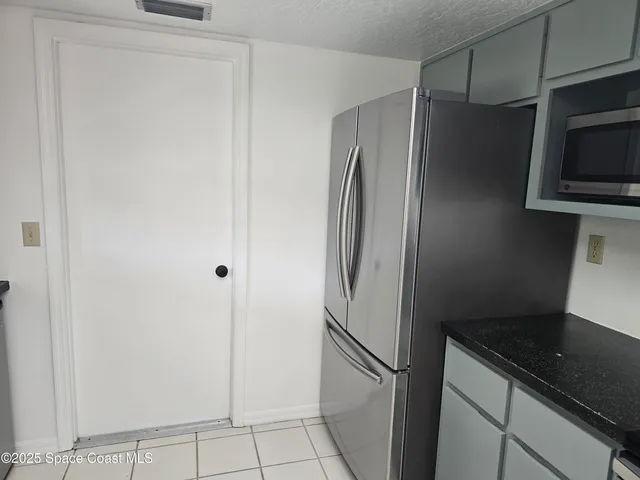 a metallic refrigerator freezer sitting in a kitchen