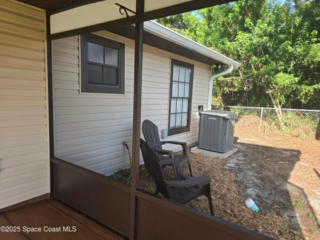 a view of a chairs and table in the back yard