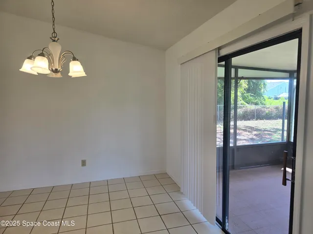 a view of a livingroom with a chandelier fan and windows