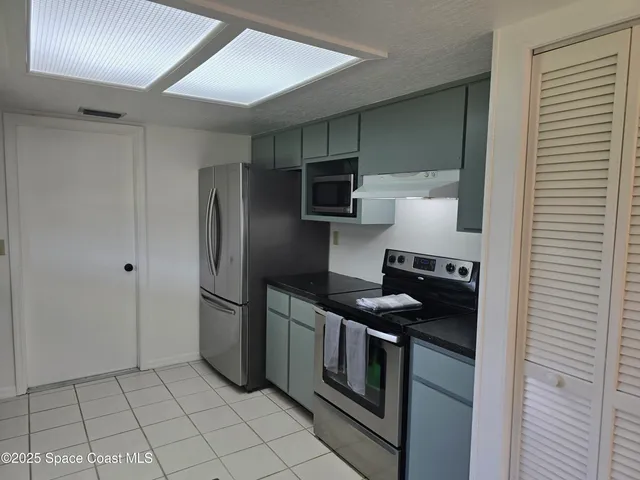 a kitchen with stainless steel appliances granite countertop a refrigerator and a stove