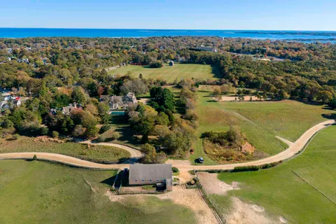 an aerial view of a house with swimming pool and lake view