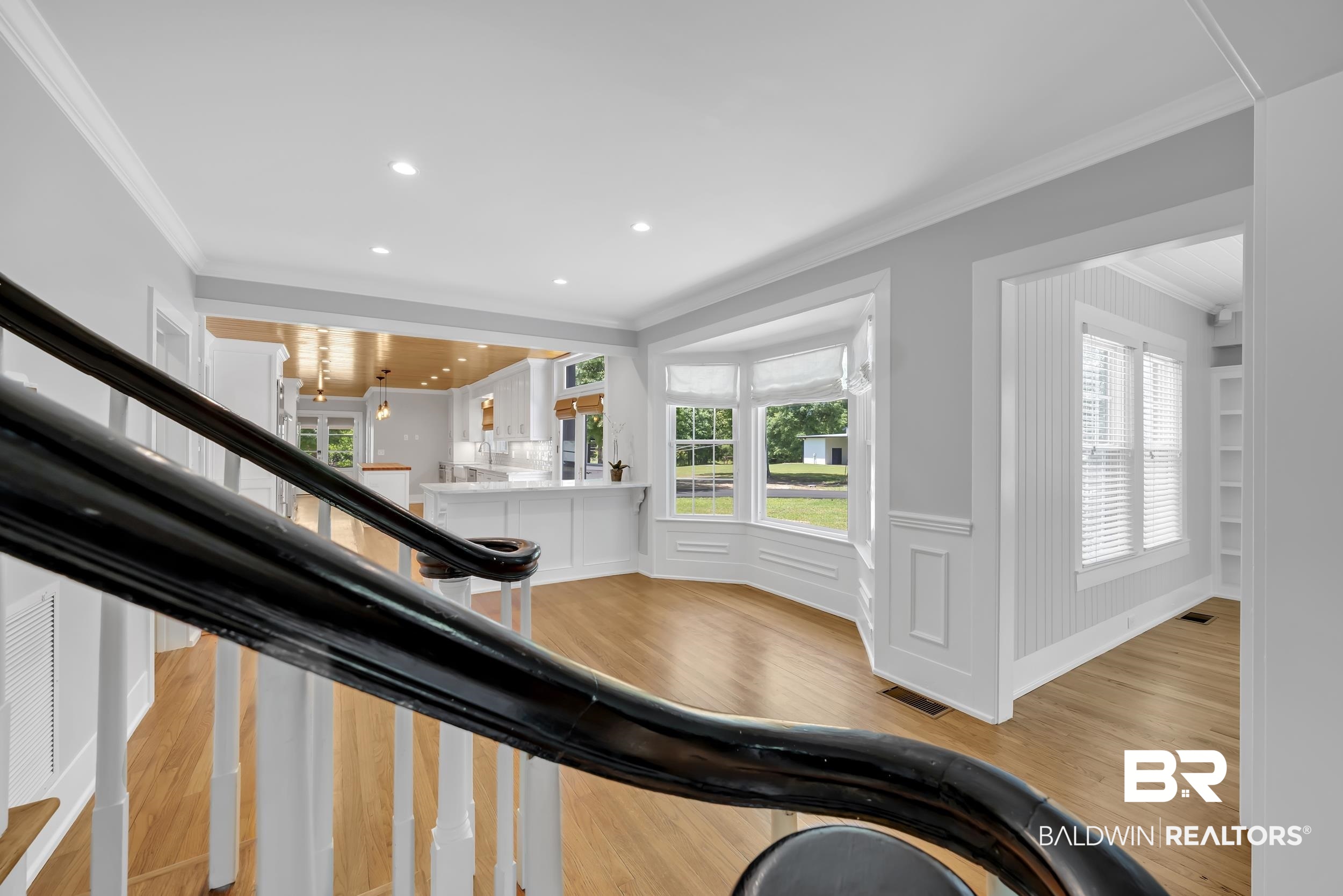 43199 Pine Grove Road Bay Minette, AL 36507 - Photo 43 of 71 Gracious entryway featuring a dark wood handrail, light wood-finish flooring, and white wainscoting