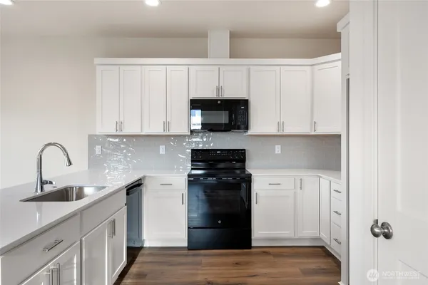 a kitchen with granite countertop a sink and dishwasher with wooden floor