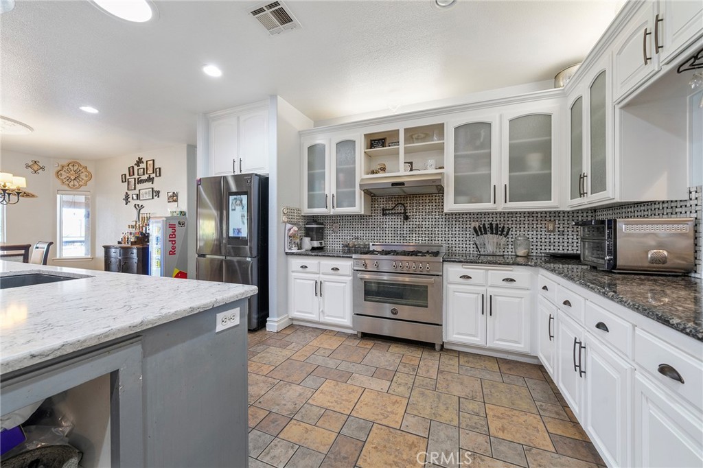 7172 Jargon Road Hesperia, CA 92344 - Photo 30 of 75 a kitchen with stainless steel appliances granite countertop a stove sink and cabinets