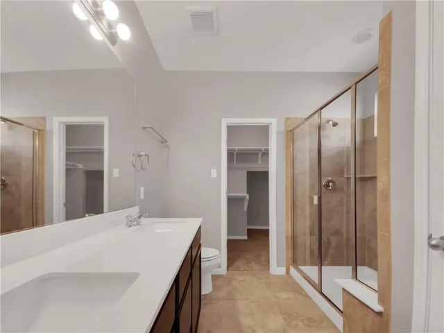 a en suite bathroom with a shower sink and mirror