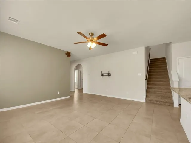 wooden floor in an empty room with a ceiling fan