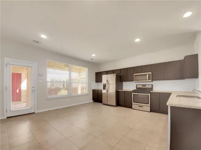 a open kitchen with refrigerator stove and cabinets